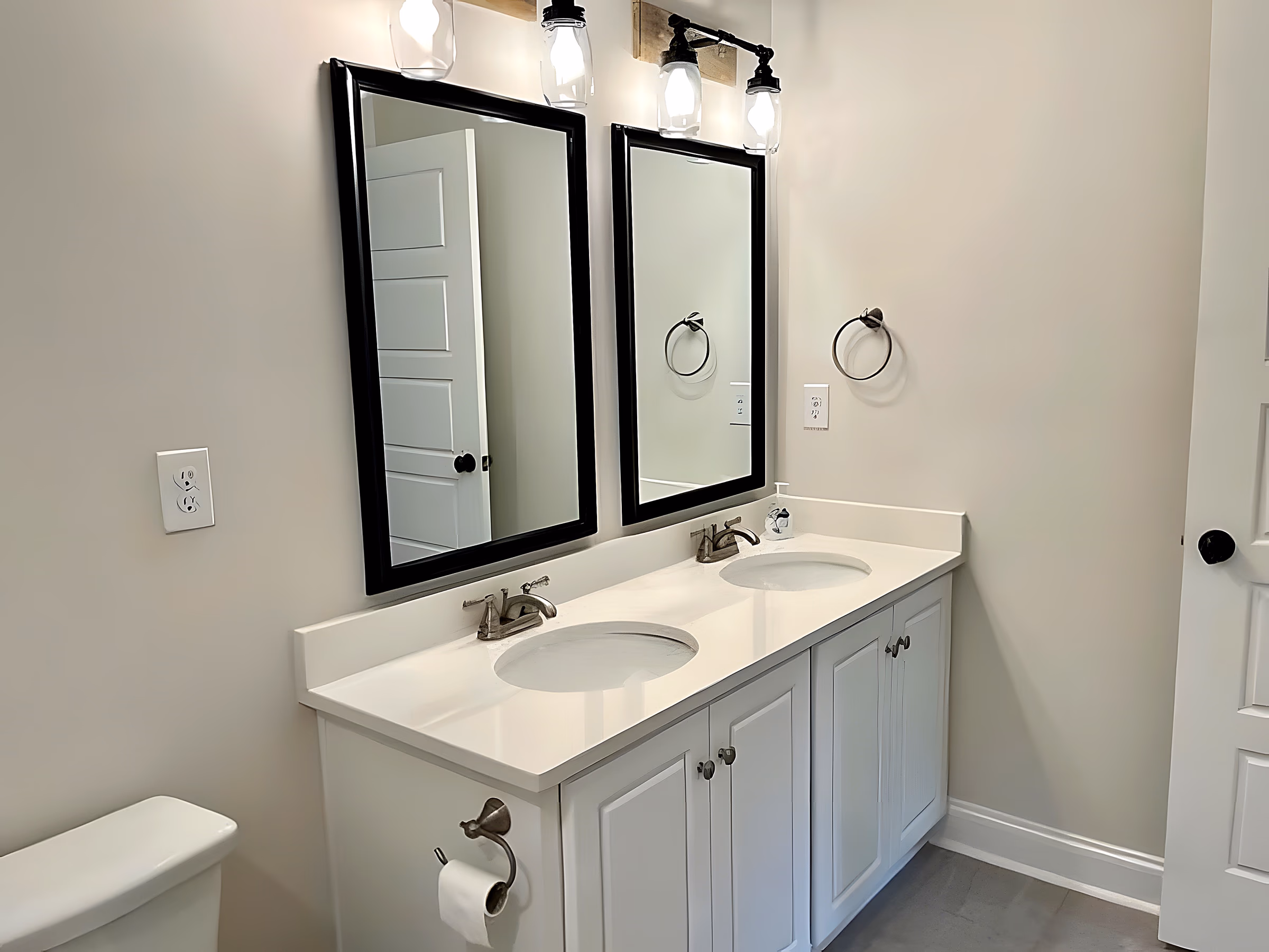 Shared secondary bathroom with double vanity and framed mirrors