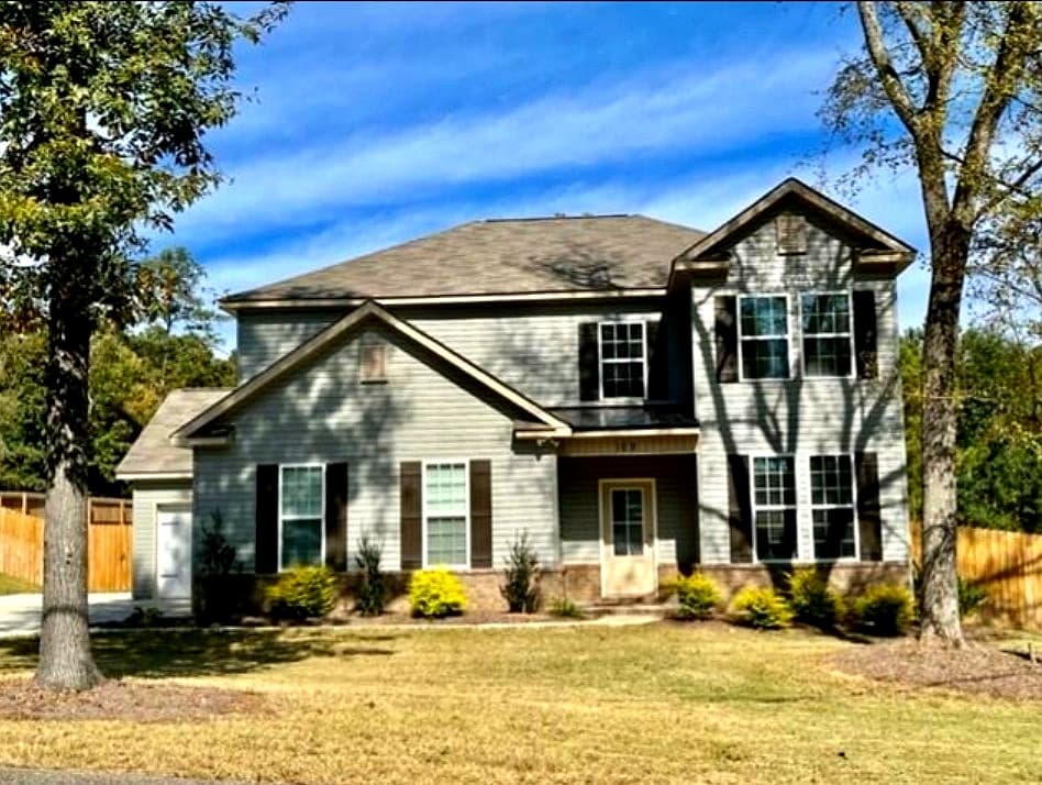 Front exterior of 109 Scott Drive with covered entry, brick skirt, and manicured landscaping