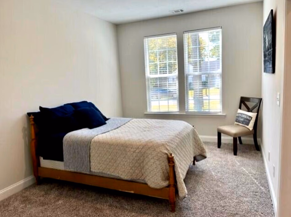 In-law suite bedroom with large windows and neutral palette