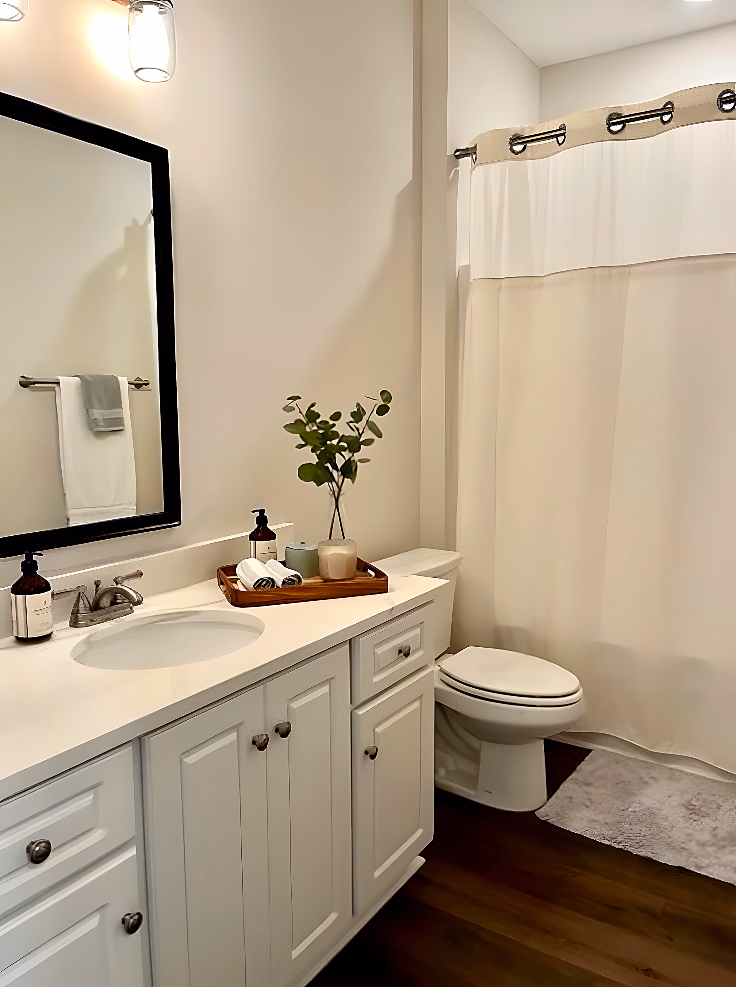 In-law suite bathroom with white vanity, framed mirror, and tub-shower