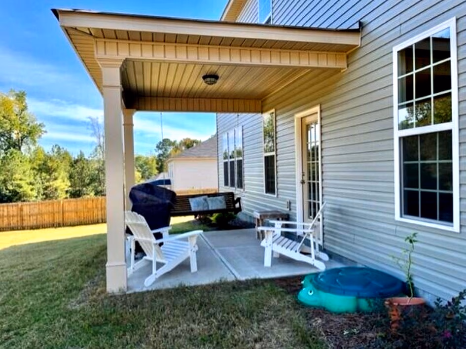 Covered patio with Adirondack chairs, grill, and porch swing